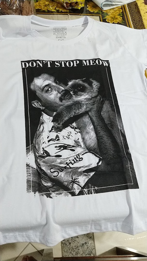 A white t-shirt with a black and white graphic of a man holding a cat with the text 'DON'T STOP MEOW'.