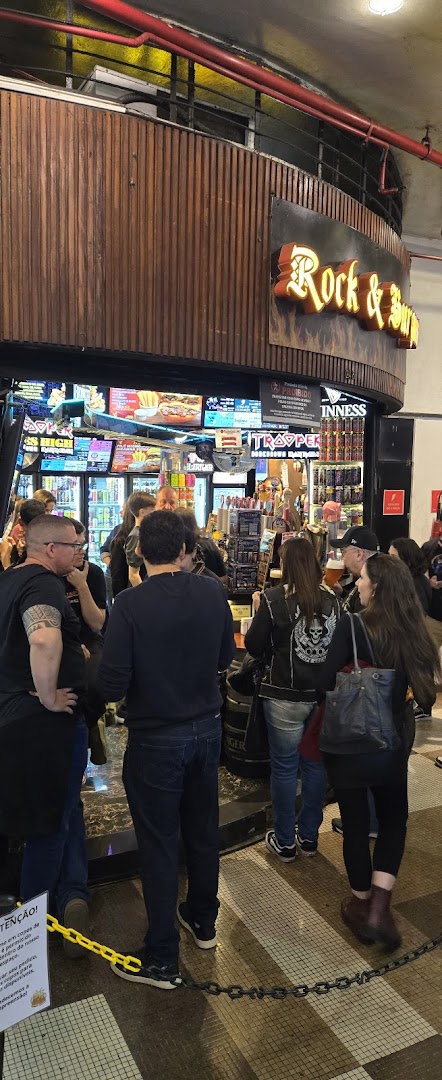People gathered at the entrance of a lively bar with a prominent "Rock & Burger" sign.