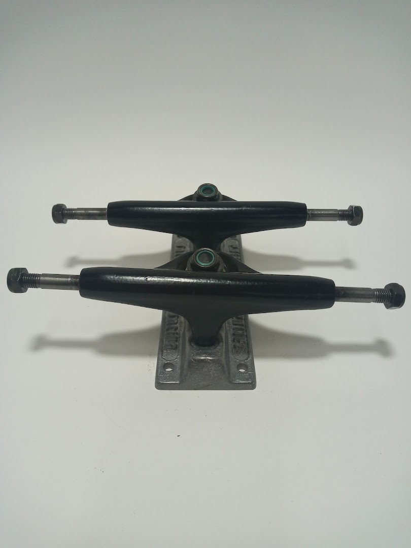 Two black skateboard trucks are displayed against a white background.