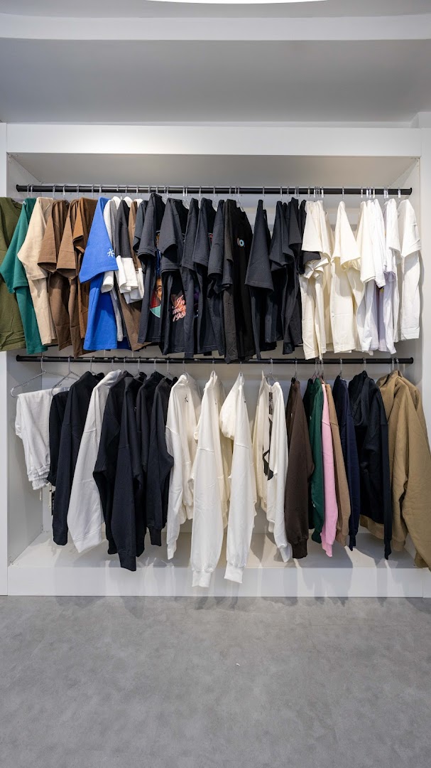 A retail display featuring rows of t-shirts and sweatshirts in various colors.