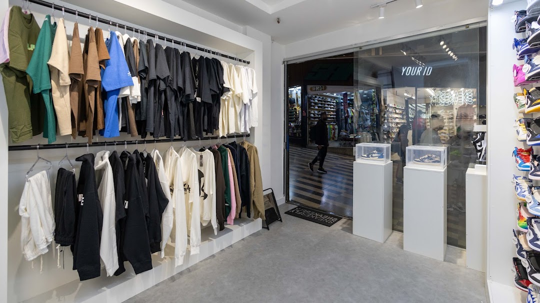 Interior of a sneaker and apparel shop with clothing racks and display cases.