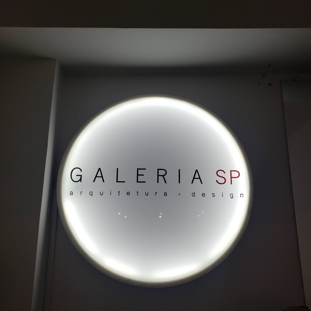 A circular illuminated sign for 'GALERIA SP arquitetura + design'.