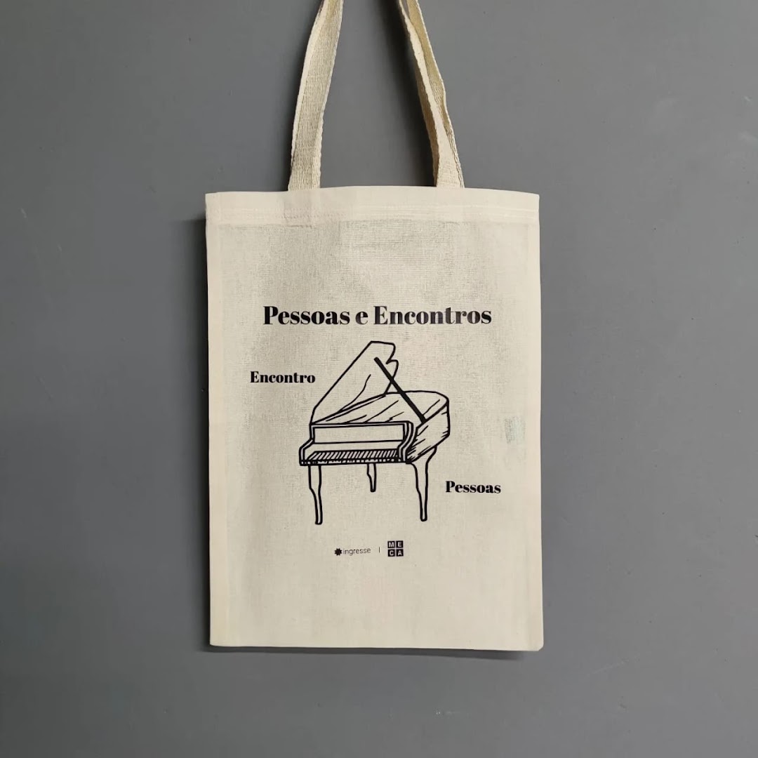 A canvas tote bag with a black and white illustration of a piano and text.
