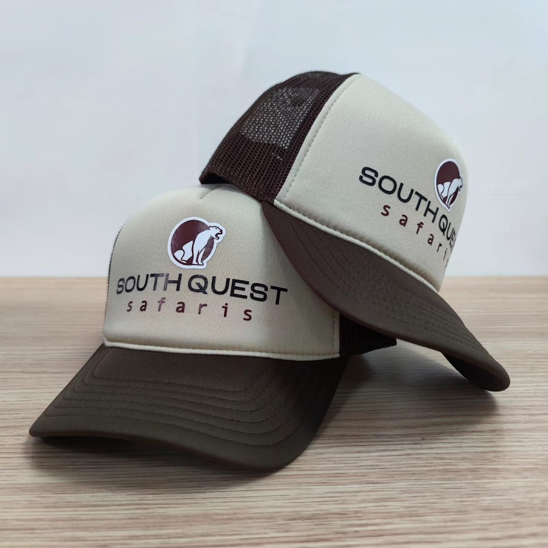 Two custom-designed trucker hats with 'South Quest Safaris' branding and a lion logo.