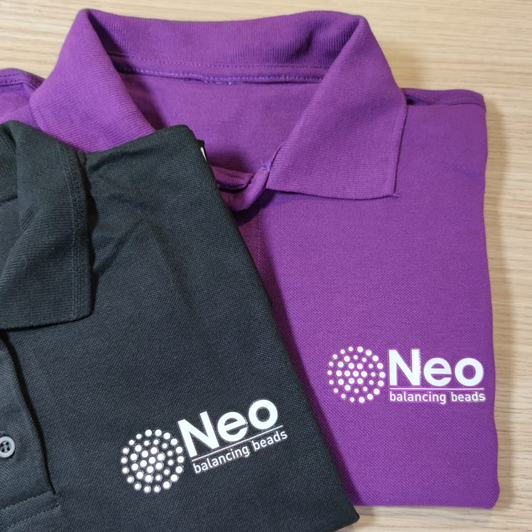 Two folded polo shirts, one black and one purple, with a white logo and text.