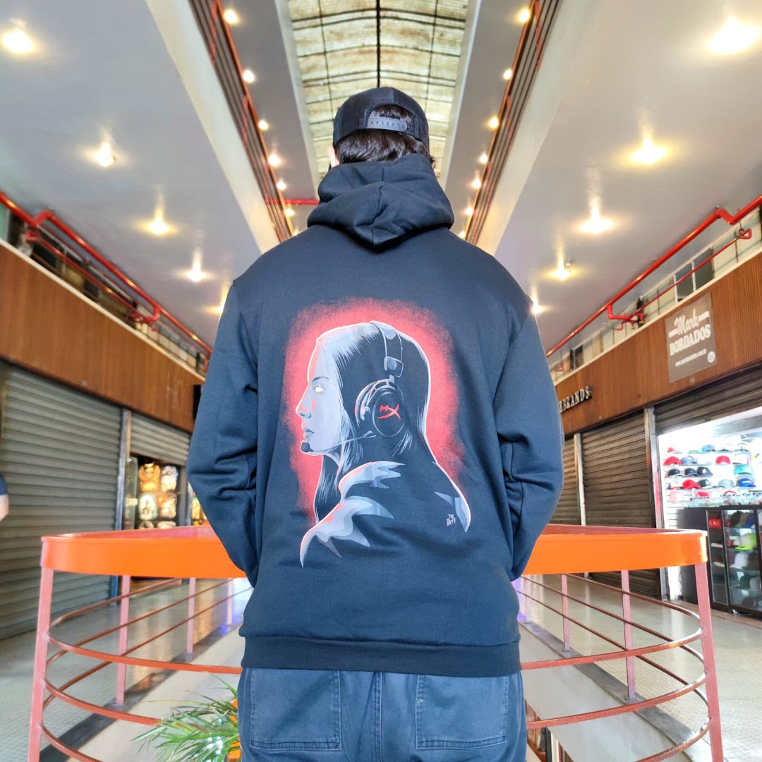 Person wearing a black hoodie with a graphic print of a woman with headphones.