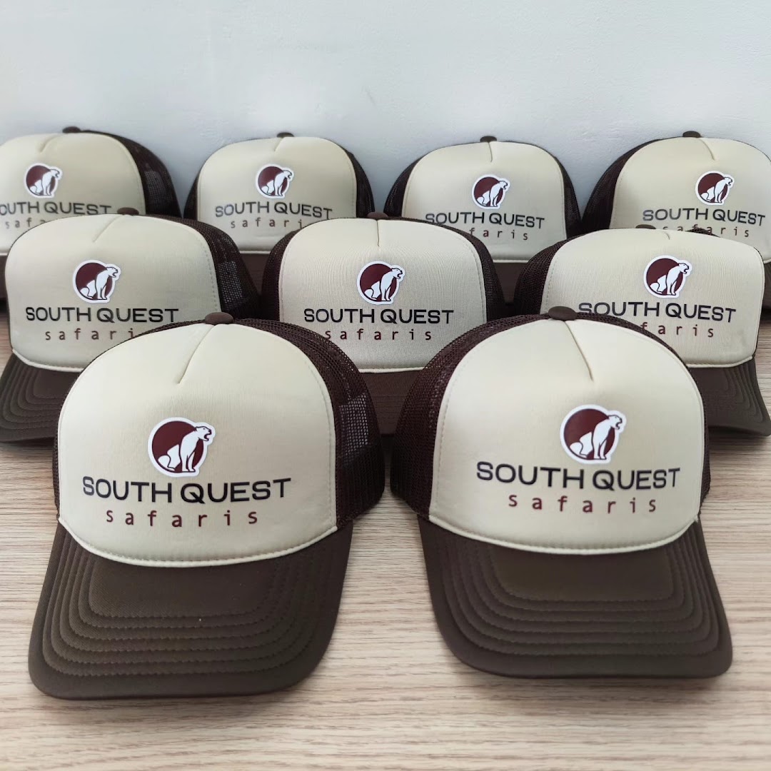 A collection of custom-branded trucker hats with a 'South Quest Safaris' logo.
