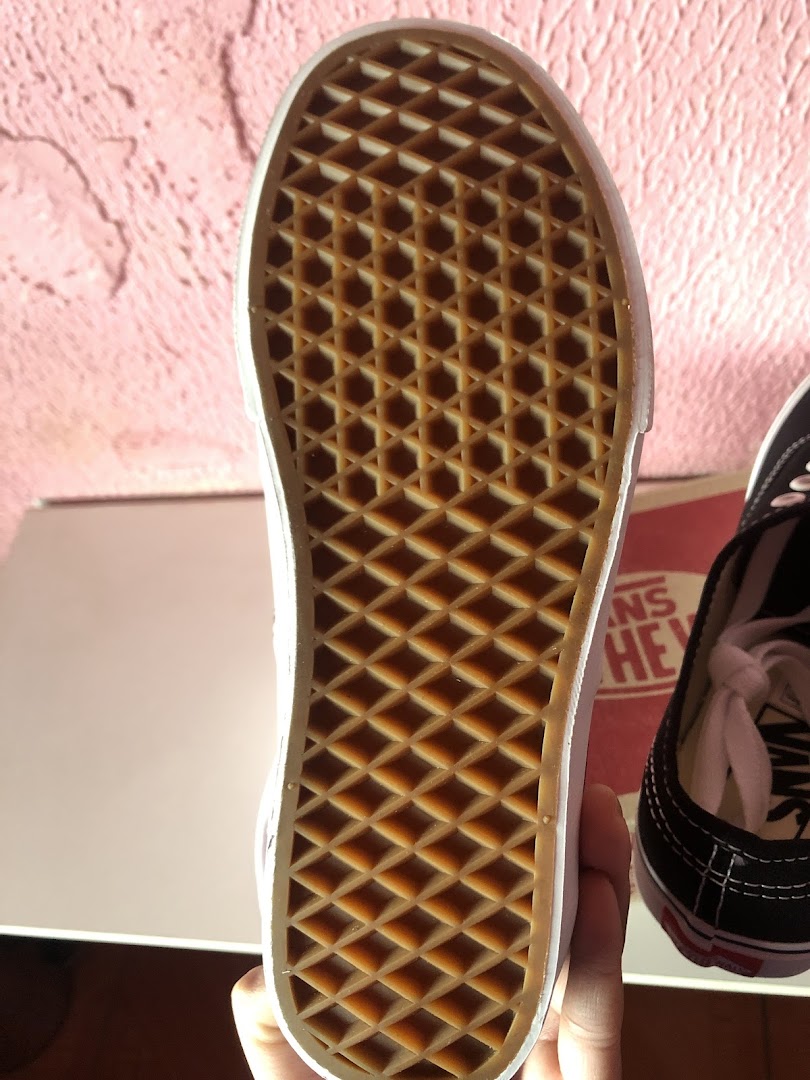 Close-up of the waffle-patterned sole of a Vans shoe, with another shoe visible.