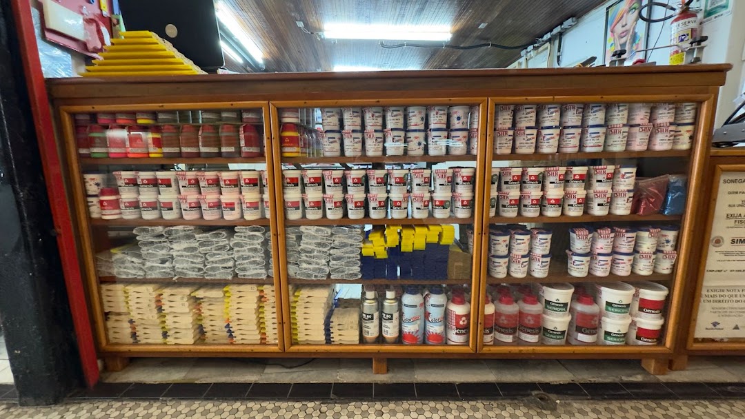 A wooden display cabinet filled with various paint cans, bottles, and sponges.