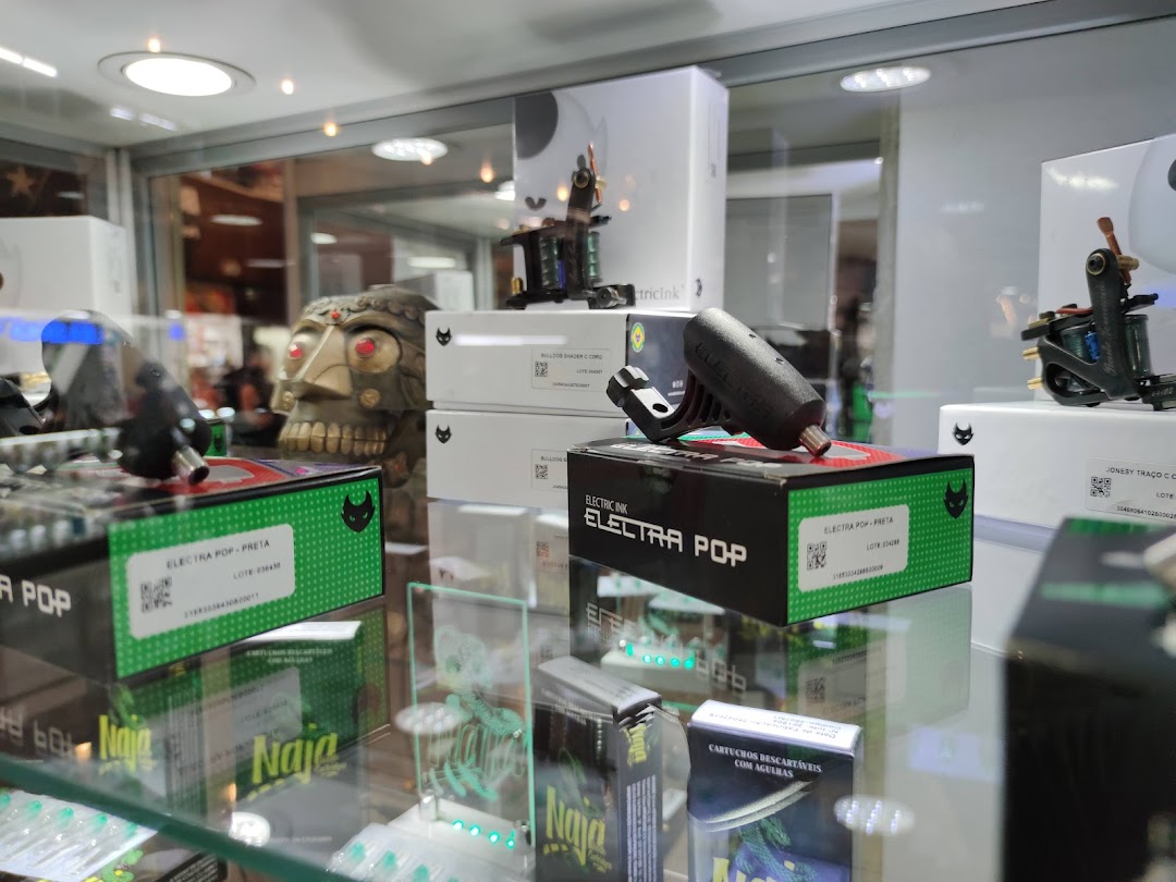 Display case filled with tattoo machines, inks, and accessories, including a skull decoration.