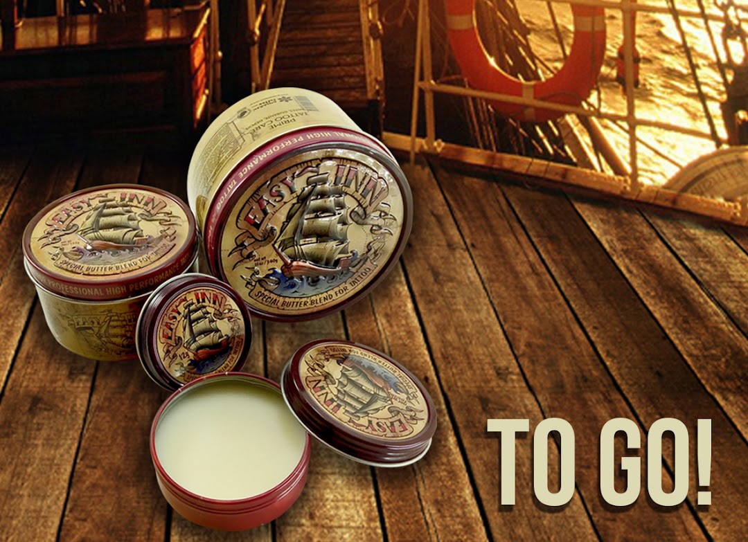 Tattoo aftercare butter tins displayed on a wooden surface with a nautical background.