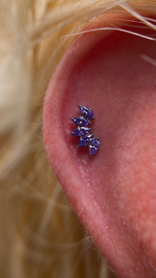 Close-up of a helix piercing with a cluster of purple marquise-cut gems.