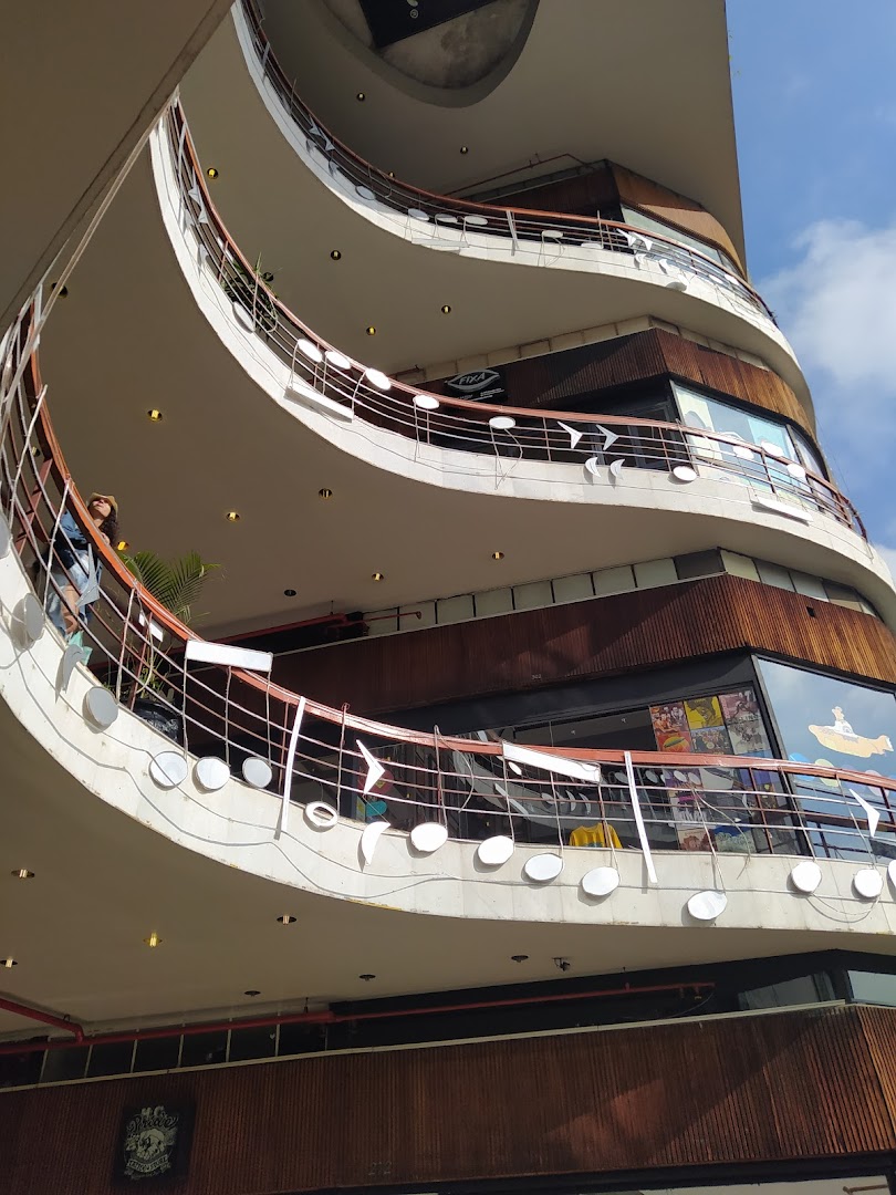 Exterior view of a multi-level building with curved balconies and musical note-themed railings.