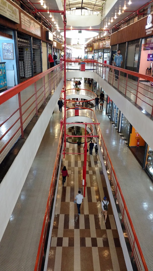 Interior view of a multi-level shopping mall with people walking on the floors.
