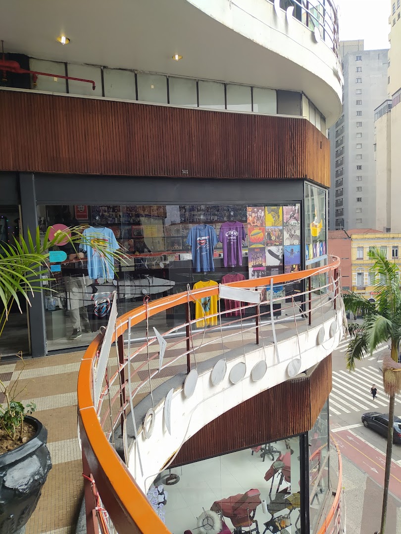 A shop called Transfer Palace displays t-shirts and records in its window, with a curved balcony in the foreground.