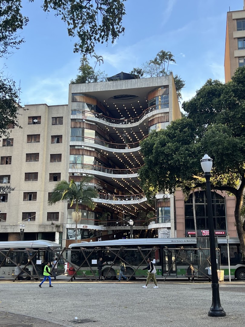A unique multi-level building with a curved facade and outdoor seating areas.