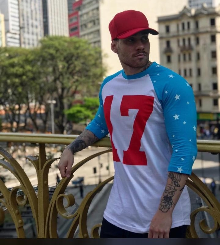 A man wearing a red cap and a white and blue baseball-style shirt with a large '17' on the front.