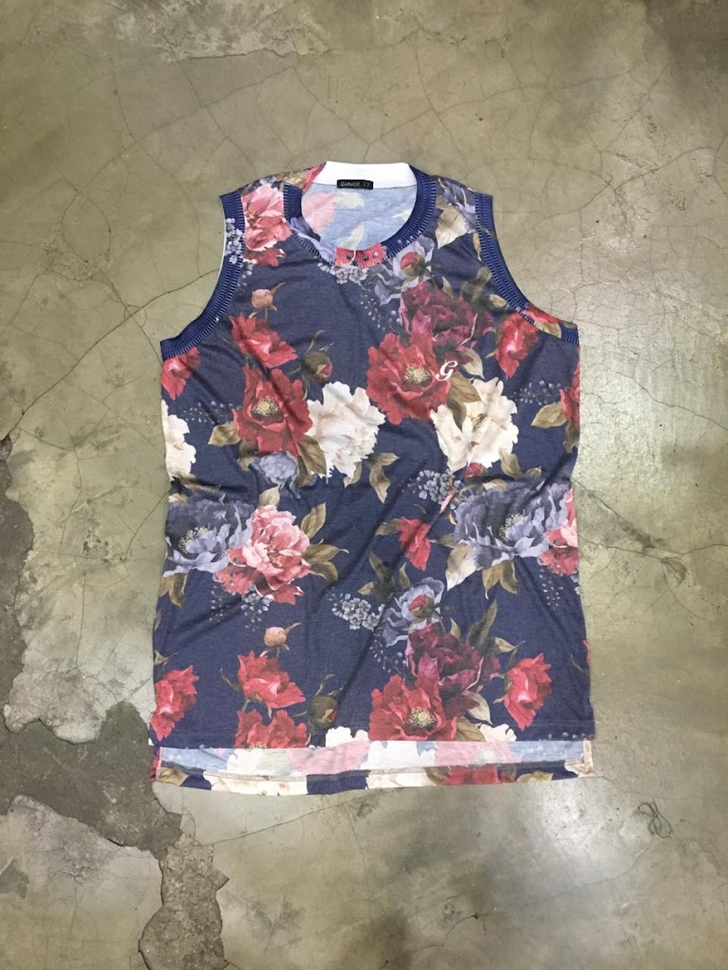 A sleeveless t-shirt with a dark blue base and a vibrant floral print.