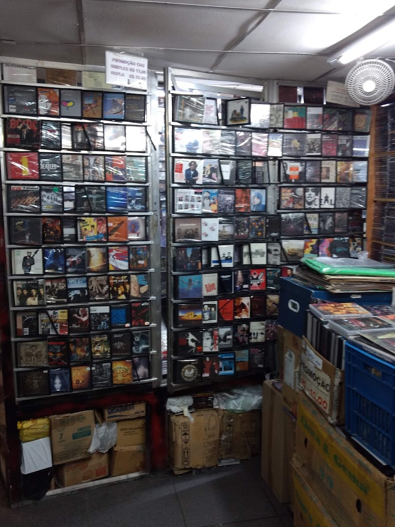 Shelves packed with CDs and DVDs, some promotional signs visible.