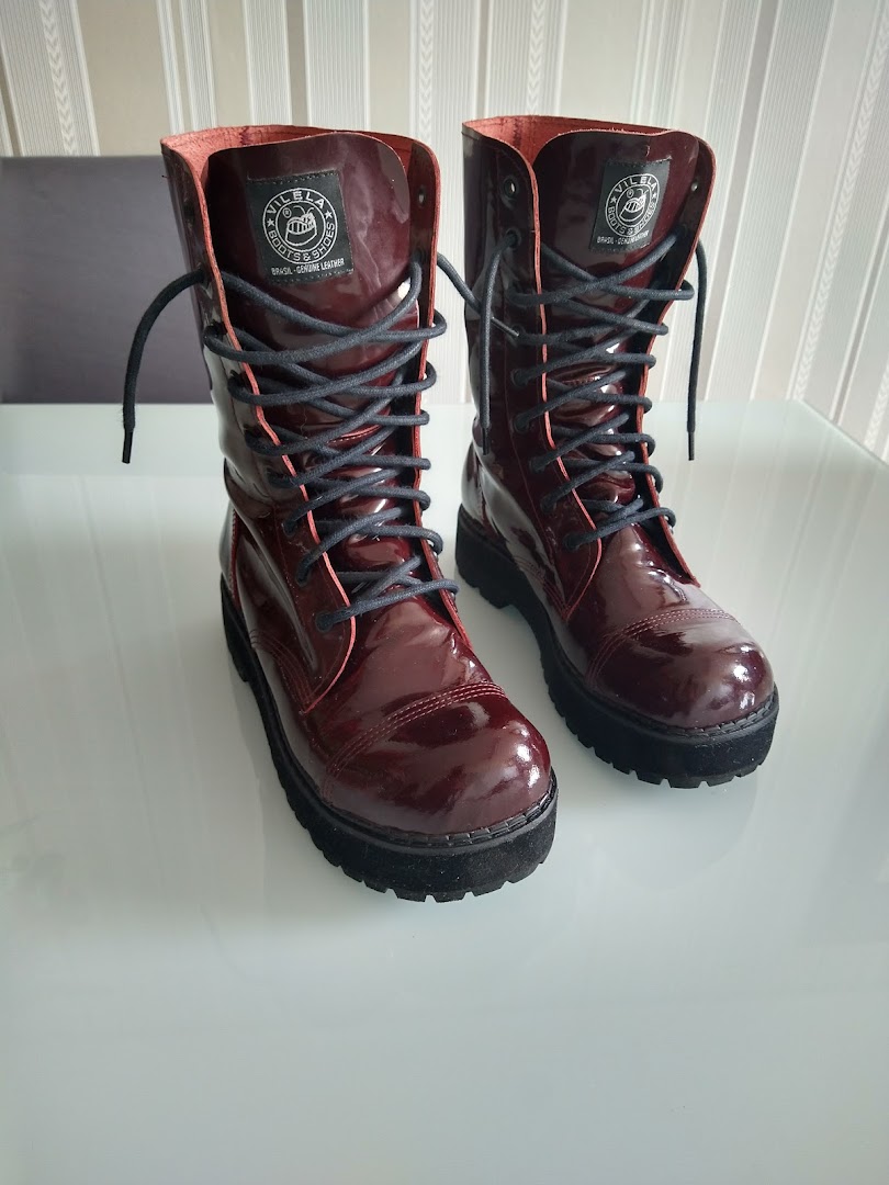 A pair of shiny, burgundy Vilela Boots with black laces and thick soles.