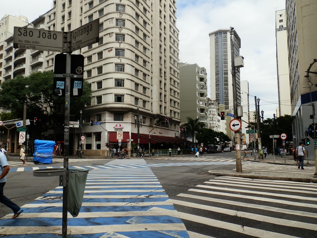 A street view of a city intersection with tall buildings and crosswalks.