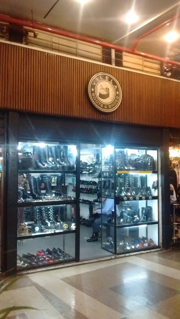 Vilela Boots & Shoes shop front displaying a wide variety of boots and shoes in glass display cases.