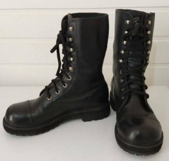 A pair of black leather lace-up boots with silver eyelets and thick soles.