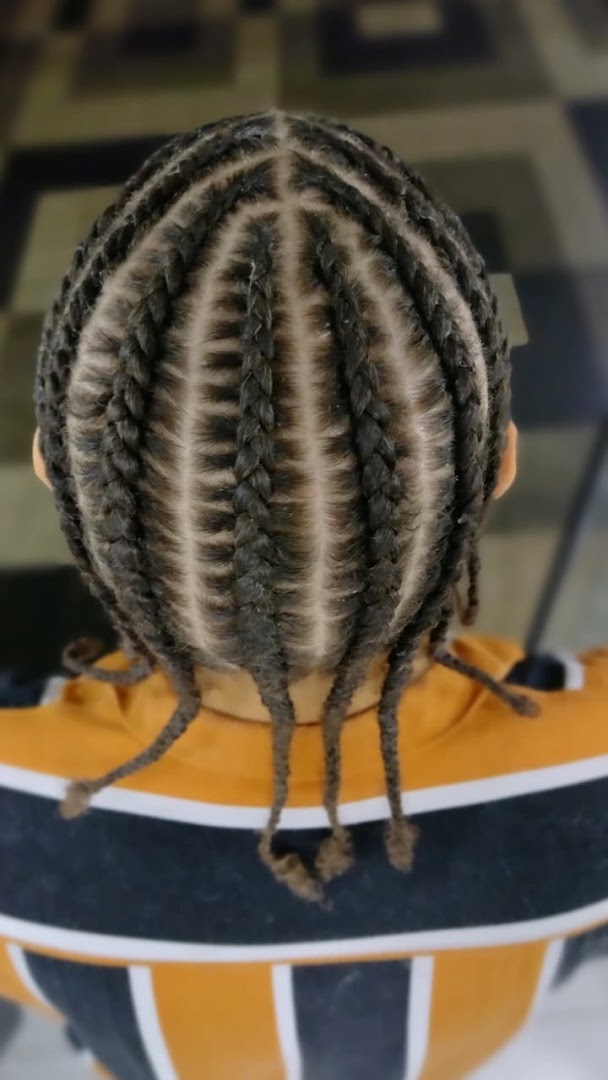 A close-up overhead view of a person's head with neatly done cornrow braids.