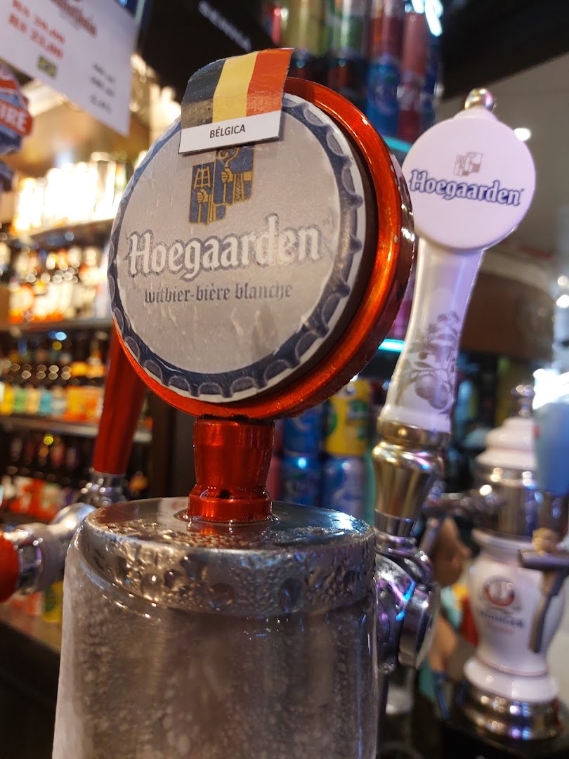 Close-up of beer taps, one featuring Hoegaarden witbier with a Belgian flag.