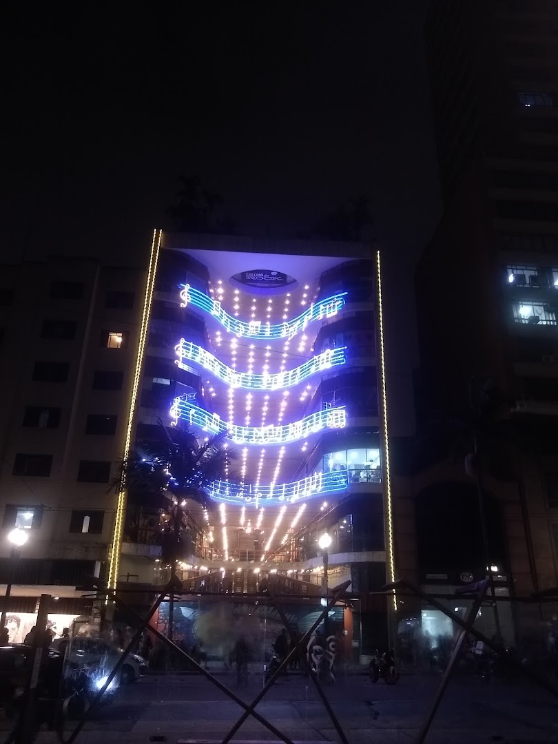 A building facade decorated with musical notes and lights at night.