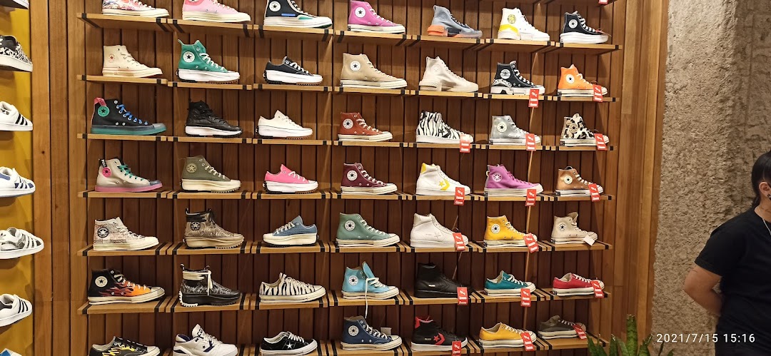 A wall display showcasing a wide variety of Converse sneakers in different colors and styles.