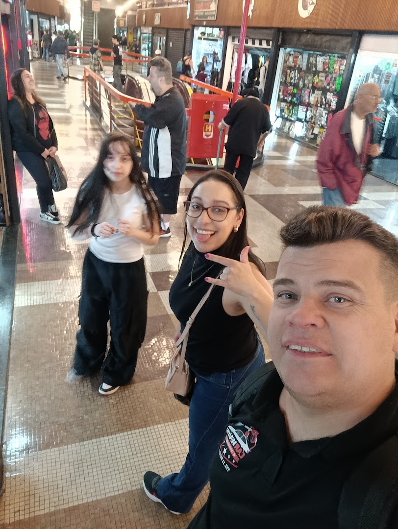 A group of people posing for a selfie in a busy shopping mall corridor.