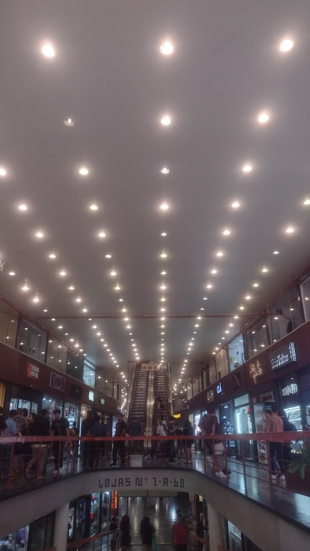 Interior view of a shopping mall with multiple levels, escalators, and shops.